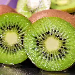 Dos mitades de kiwi jugosas, con sus semillas negras y pulpa verde vibrante, listas para ser plantadas o disfrutadas.
