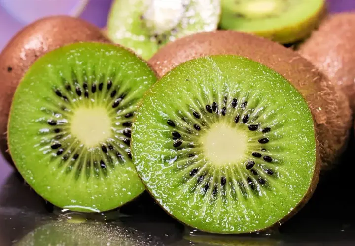 Dos mitades de kiwi jugosas, con sus semillas negras y pulpa verde vibrante, listas para ser plantadas o disfrutadas.