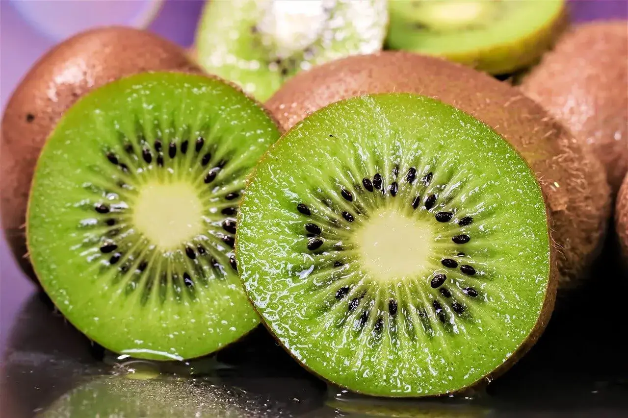 Dos mitades de kiwi jugosas, con sus semillas negras y pulpa verde vibrante, listas para ser plantadas o disfrutadas.